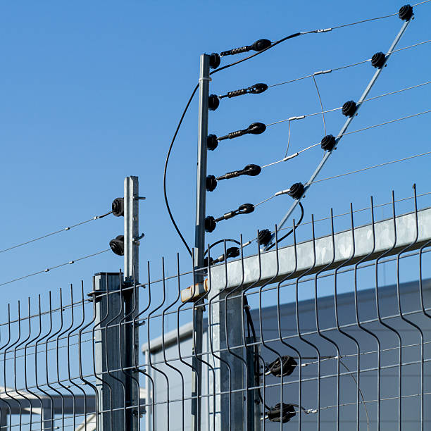 view of an electric fence installation on a metallic grilled fence